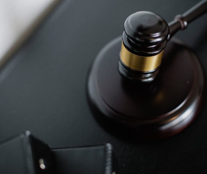 Close-up of a wooden judge's gavel on a black desk, symbolizing justice and law.