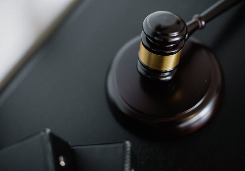 Close-up of a wooden judge's gavel on a black desk, symbolizing justice and law.