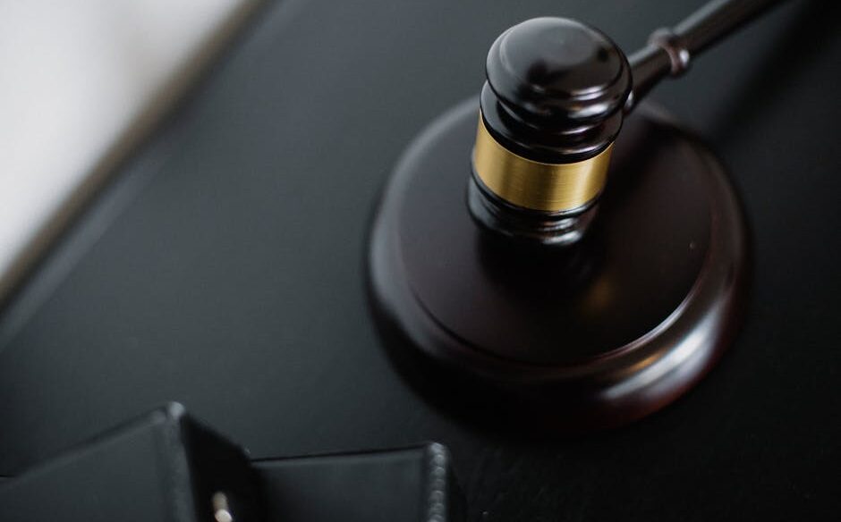 Close-up of a wooden judge's gavel on a black desk, symbolizing justice and law.