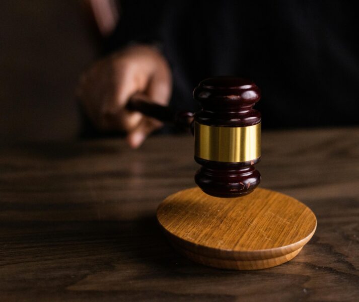A gavel striking a sound block, symbolizing justice and legal authority in a courtroom setting.
